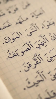 Close-up of handwritten Arabic script on grid notebook paper in black ink modern standard arabic for students